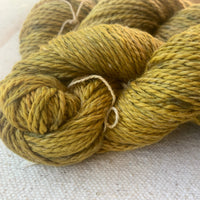 Textured skein of yellow speckled yarn